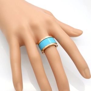 Macro detail of wide industrial style ring with blue resin center and gold studded edges