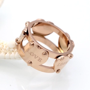 Vue macro d'une bague coeur ajourée en or rose avec gravure LOVE et fini poli