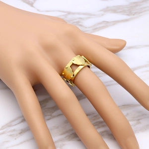 Bague double cœur doré avec gravure LOVE portée sur l'index d'une femme