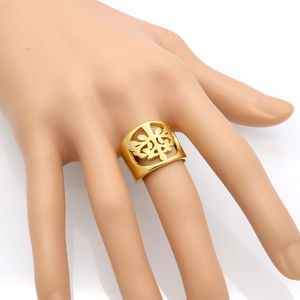 Vergoldeter hohler Lebensbaum Ring aus Edelstahl an der Hand vor weißem Hintergrund