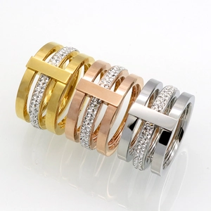 Detail of three-tier rings in gold, silver, and rose gold with T-shape pave diamonds