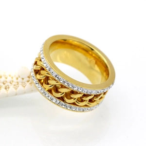 Detail of gold chain spinner ring with double rows of zircon crystals on white background