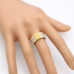 Bague dorée à trois rangs de cristaux avec plaque en métal sur la main d'un mannequin