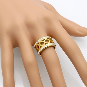 Gold wide band infinity ring with double row crystals shown on a model hand