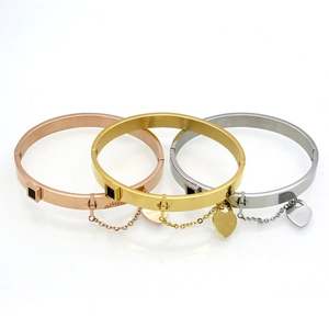 Detailed macro view of three-color stainless steel bracelets with heart charms and chain