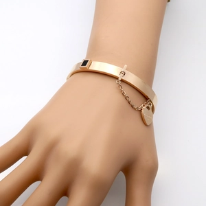 Rose gold stainless steel bangle with black square inlay and heart charm chain