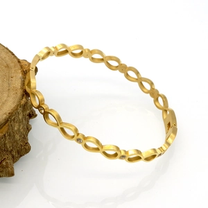 Détail du bracelet infini doré avec finition brossée et cristaux étincelants incrustés