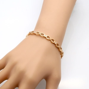 Bracelet à maillons infinis en or rose serti de cristaux pavé porté au poignet