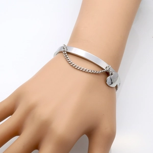 Polished stainless steel heart charm bangle featuring Forever Love engraving on hand model