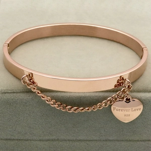 Detail of rose gold stainless steel heart charm bracelet with Forever Love engraving