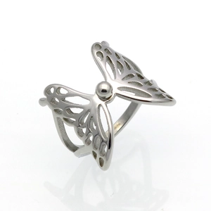 Vista de detalle del anillo de metal plateado pulido con diseño de alas de mariposa