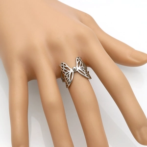 Elegante anillo de alas de mariposa caladas en plata usado en el dedo de una modelo
