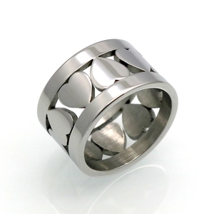 Vue macro d'une bague large ajourée avec motifs de cœurs en acier titane argenté poli