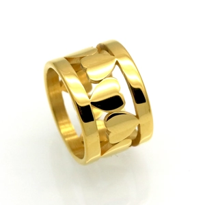 Vue détaillée d'une bague large dorée en acier inoxydable avec des motifs cœurs ajourés