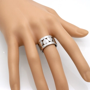 Bague large en acier inoxydable avec motifs de cœurs évidés portée sur un mannequin
