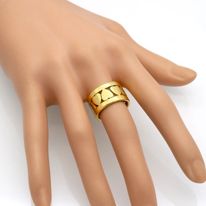 Bague large avec motif de cœur évidé en finition dorée sur fond blanc avec reflet