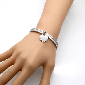 Macro shot of stainless steel heart bangle with micro-pave zircons and engraved charm