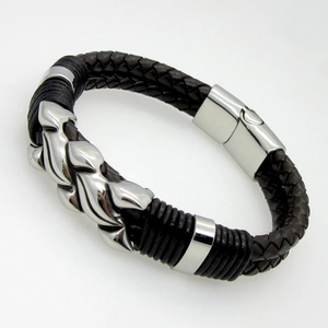 Macro detail of men's black braided leather bracelet with wavy silver steel charm