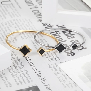 Detail of gold and silver stainless steel bangles with star enamel on a newspaper background