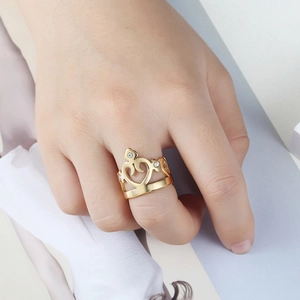 Bague couronne dorée avec motif cœur et trois zircons portée sur la main d'un modèle