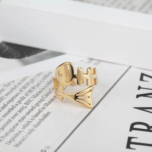 Vintage punk style fishbone open ring in gold finish shown on a lifestyle magazine background