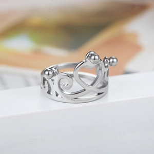 Elegant silver crown ring featuring hollow heart patterns and intricate swirl details