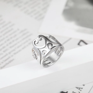 Retro hollowed silver crown ring with vintage scroll pattern on a white platform