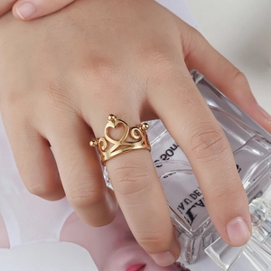 Elegant gold hollow heart crown ring worn on hand with a stylish lifestyle background