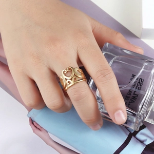 Vintage golden hollow crown ring with intricate scroll patterns worn on hand