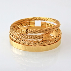 Gros plan sur l'ensemble de bracelets en acier doré avec charms couronne et chiffres romains