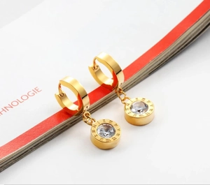 Detail view of rose gold roman numeral cylinder earrings with sparkling cubic zirconia