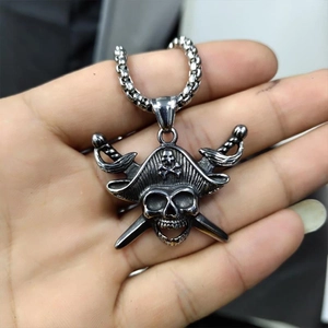 Vintage pirate skull pendant necklace in retro steel held in palm for detail