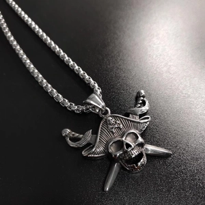 Detailed macro view of vintage silver pirate skull and cross swords pendant in steel