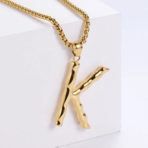 Vue détaillée du pendentif lettre K en or 18 carats avec surface texturée en bambou