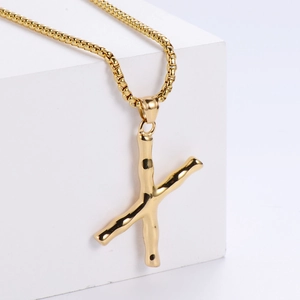 Détail du pendentif lettre X doré avec texture bambou 3D sur une chaîne à mailles