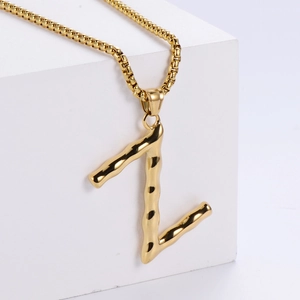 Détail du pendentif lettre Z doré en 3D avec texture bambou sur une chaîne mailles carrées
