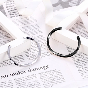 Minimalist silver and black polished stainless steel cuff bracelets on fashion magazines