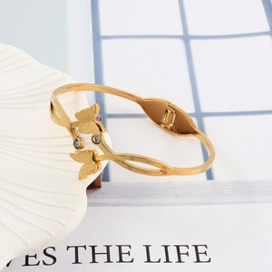 Close-up of golden stainless steel butterfly bracelet with matte finish and rhinestones