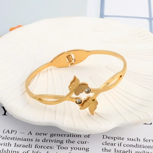 Detail of gold butterfly bracelet with matte finish and zircons in shell dish