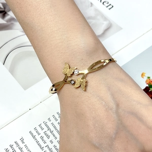 Detail of gold butterfly bracelet with frosted texture and sparkling round diamonds