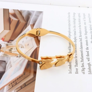Detailed shot of golden stainless steel butterfly bracelet with frosted texture and zircon