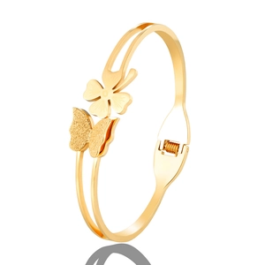 Detail of gold butterfly and clover bangle with matte finish and spring clasp closure