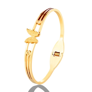 Detail of golden butterfly bangle with frosted texture and rhinestone embellishments