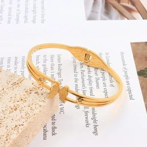 Detail of matte gold butterfly bracelet with crystal accents and double-line hollow band
