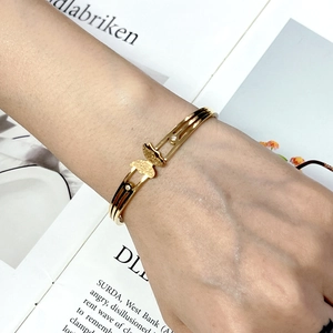 Close-up of golden butterfly bangle with matte finish and crystal accents on wrist