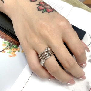 Dettaglio di un anello in argento multistrato a nodi indossato con uno stile moderno