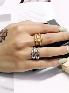 Dettaglio di anelli incrociati minimalisti oro e argento con trama a righe sottili