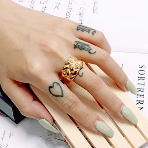 Close-up of a wide 18K gold plated braided stainless steel ring worn on the finger