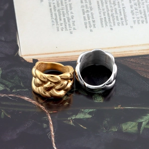 Close-up of gold and silver braided stainless steel rings on a vintage book background