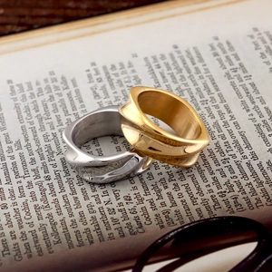 Artistic wavy twist design rings in gold and silver finish on vintage book pages